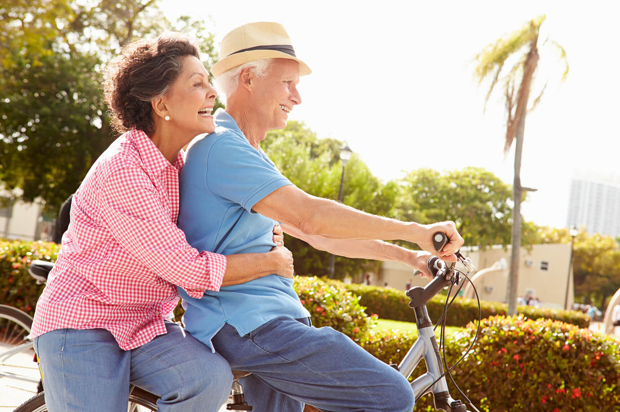 Senior couple riding bikes in park