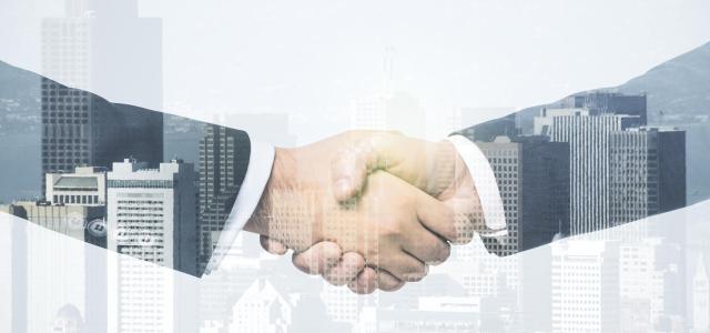 Multi exposure of handshake of two businessmen on city skyscrapers background, collaboration and teamwork concept